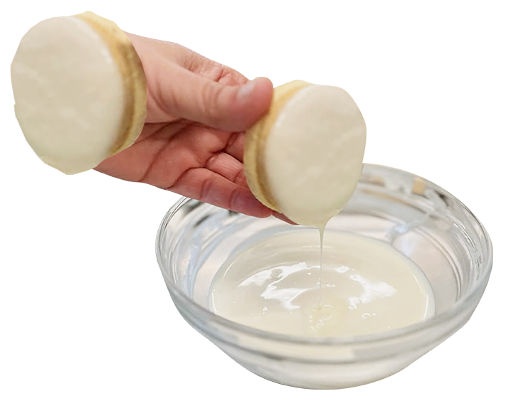 Bañando un alfajor en chocolate blanco